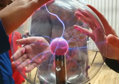 Children's hands on top of a plasma ball